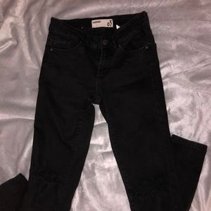 Black jeans ripped at the knees